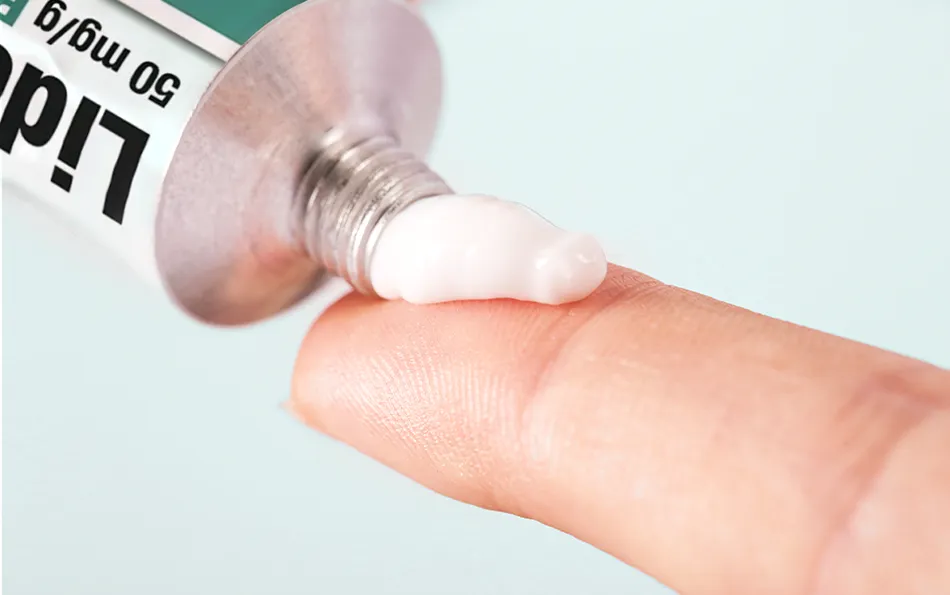 Lidoproct einfache Anwendung Nahaufnahme eines Zeigefinger, auf den Salbe aus einer Lidoproct Tube gedrückt wird