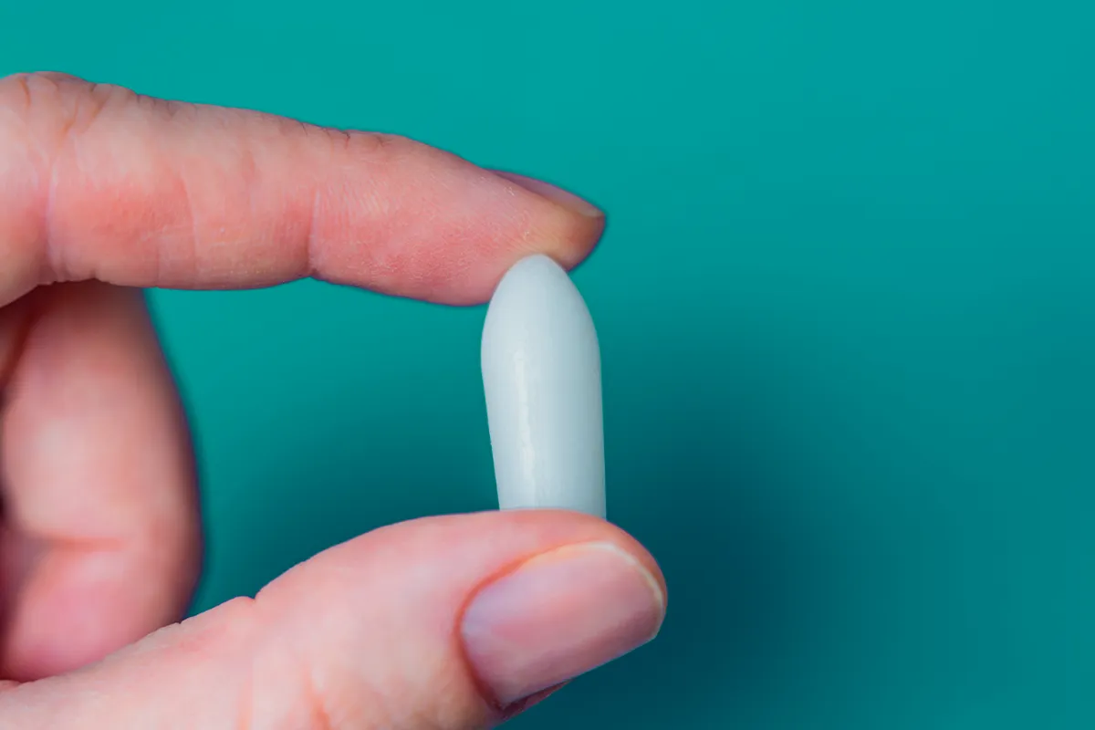 Medikamentoese Behandlung bei Hämorrhoiden Ein Zäpfchen zwischen Zeigefinger und Daumen