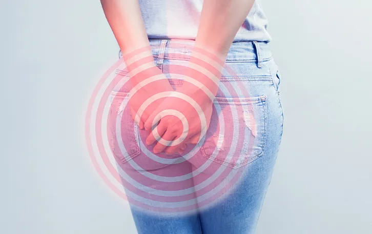 Eine Person hält sich beide Hände in der Höhe Ihrer Jeanshosentaschen auf das Gesäß. Schemenhaft sind rötliche Kreise über die gehaltene Stelle gemalt