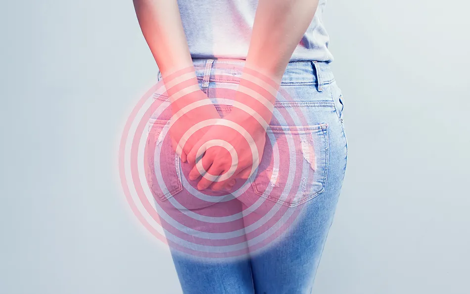 Schmerzen beim Stuhlgang gereizte Haut Eine Person hält sich beide Hände in der Höhe Ihrer Jeanshosentaschen auf das Gesäß. Schemenhaft sind rötliche Kreise über die gehaltene Stelle gemalt